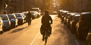 Ein Fahrradfahrer radelt in den Sonnenuntergang