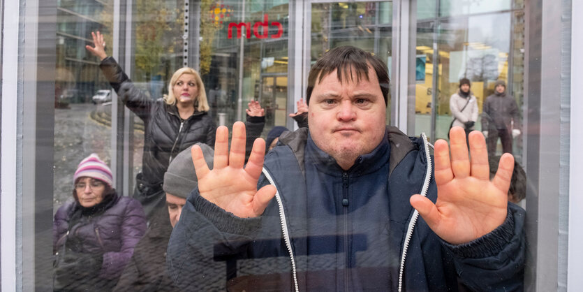 Eine Gruppe von Menschen mit Behinderung in einem Glaskäfig