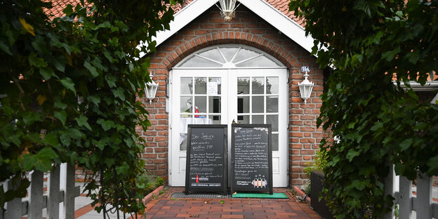 Hinweisschilder stehen vor dem Restaurant "Alte Scheune" in Leer.
