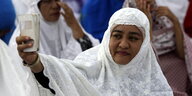 eine muslimische weiß verschleierte Frau macht ihr Selfie