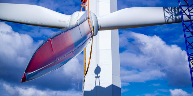 Rotorblätter einer Windkraftanlage werden mit einem Kran gehoben