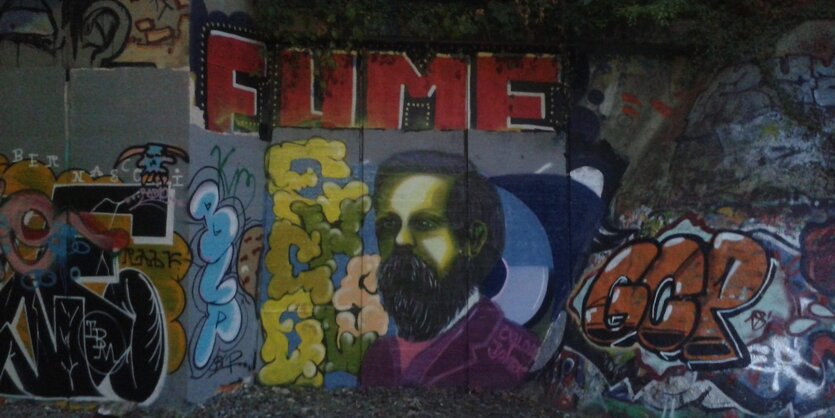 Gemälde von Friedrich Engels an einer Hauswand mit weiterer Streetart