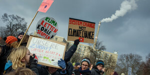 Protestierende Menschen mit dem Schild "Sxstem change not climate change"