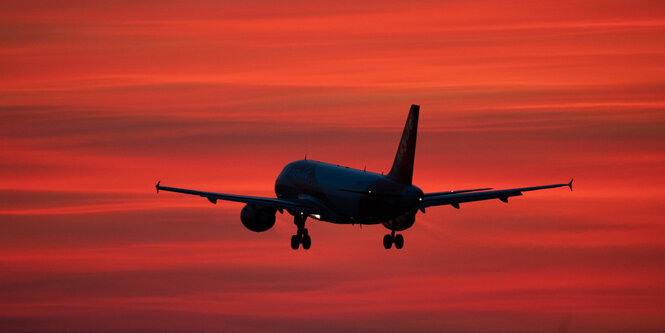 Ein Flugzeug vor rotem Himmel.