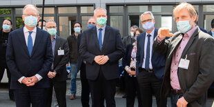 Eine Gruppe von Männern mit Masken schaut in die Kamera