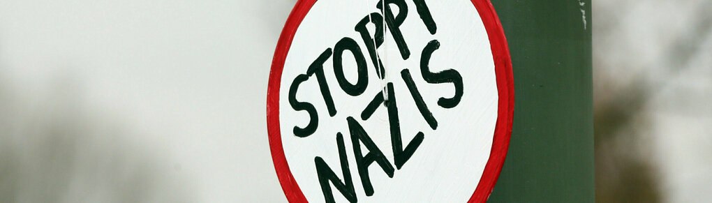 Ein Schild mit der Aufschrift "Stoppt Nazis"