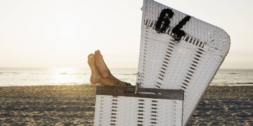 Füße ragen aus einem Strandkorb