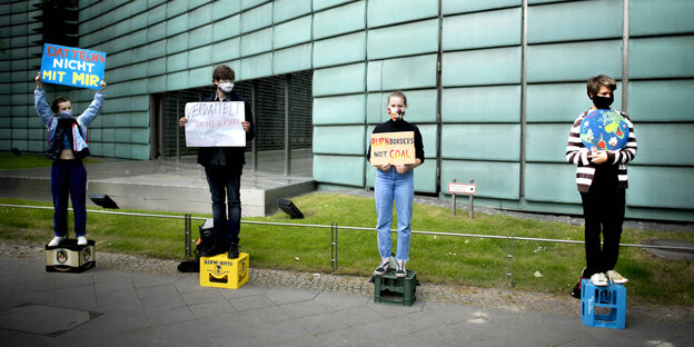 Jugendliche Demonstranten mit Pappschildern, auf den Klimaprotest-Slogans stehen