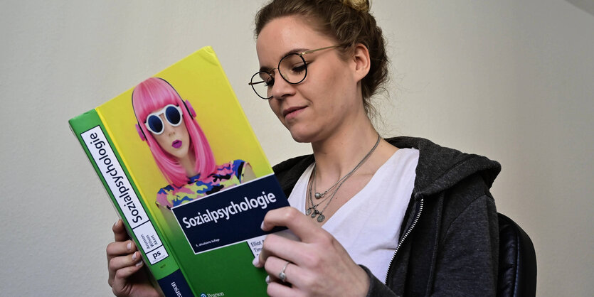 Studentin liest in einem Psychologiebuch.