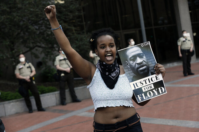 Demonstrantin mit Bild von Polizeiopfer George Floyd.