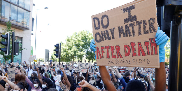 Protestierende recken die Fäuste hoch, ein Schild, auf dem steht: "do I only matter after death # George Floyd"