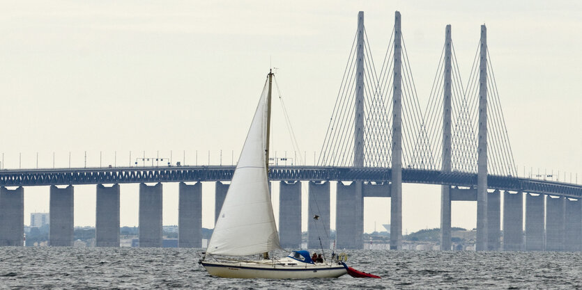 Ein Segelbott auf dem Wasser vor einer Brücke