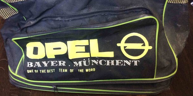 eine Sporttasche mit großem Opel-Logo, auf der steht "Bayern München, one of the best teams in the world"