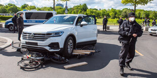 Ein SUV fährt bei einer Protestaktion über Fahrräder