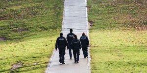 mehrere polizisten laufen durch einen park