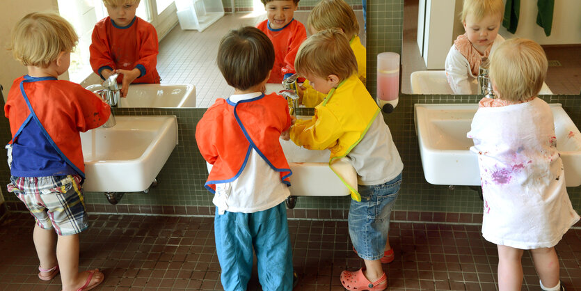 Kleinkinder stehen an Waschbecken