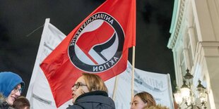 Demonstranten halten eine Antifa-Fahne