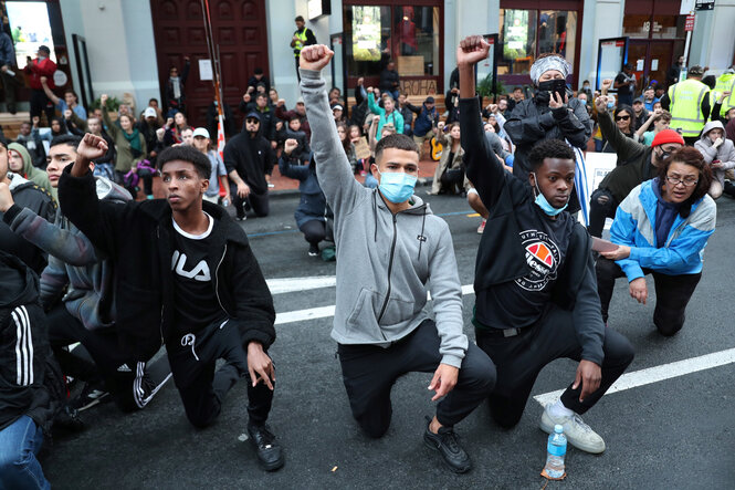 Demonstranten knien auf der Straße.