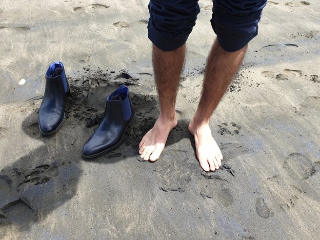 Füße an einem Sandstrand.