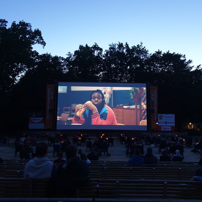 Menschen sitzen in einem Freiluftkino