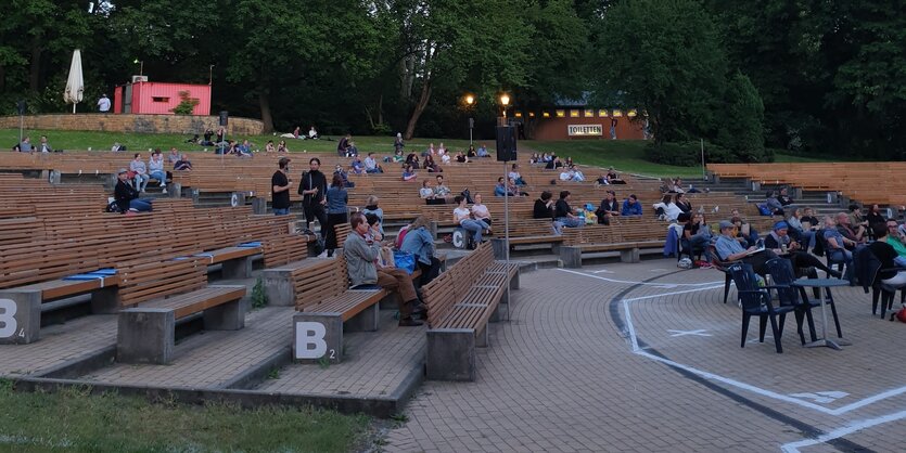 Menschen sitzen auf Parkbänken