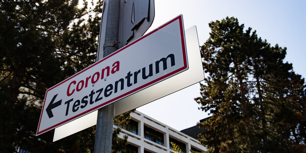 Ein Schild mit der Aufschrift "Corona Testzentrum" ist an einer Pfosten an der Universitätsmedizin Göttingen zu sehen.