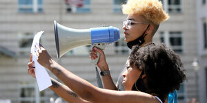 Zwei Frauen protestieren mit Megaphon