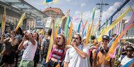 Demonstranten mit bunten Fahnen pfeifen