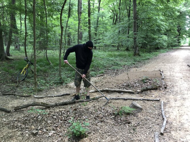 Eine Person mit einem Rechen im Wald