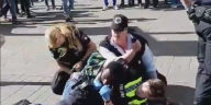 Polizisten fixieren einen Menschen auf dem Boden