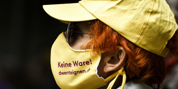Frau mit Mundschutz bedruckt mit einem Slogan