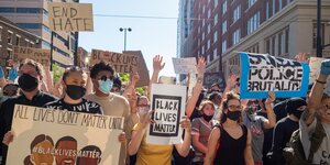 Demonstrierende tragen Plakate mit "Black lives matter"-Slogans