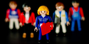 Eine weibliche und vier männliche Playmobil-Spielfiguren