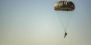 Ein militärischer Fallschirmspringer am blauen Himmel