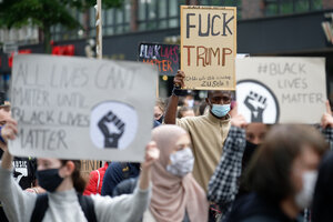 Demonstrierende Menschen in Düsseldorf halten Plakate in die Höhe. Auf einem steht: "Fuck trump"