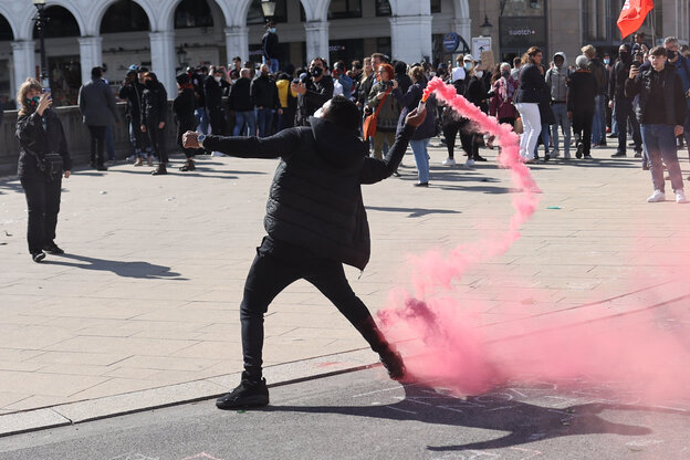 Ein demonstrant wirft eine rote rauchbombe.