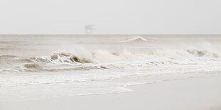 Wellen brechen am Strand