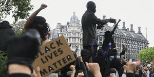 Menschen demonstrieren, einer trägt ein "Black lives matter"-Schild