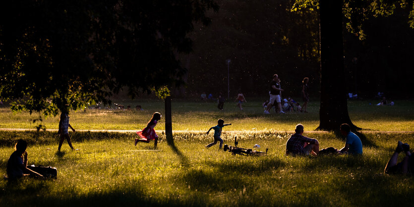 Kinder im Park laufen über die Wiese