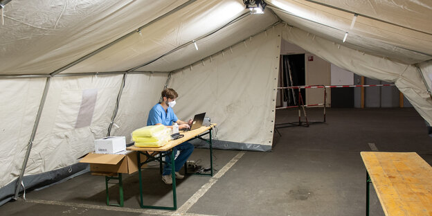 Ein medizinischer Helfer arbeitet in einem aufgebauten Zelt für die Covid-19-Testung in der Tiefgarage des Iduna-Zentrum.