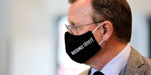 Ministerpräsident Bodo Ramelow mit einer Gesichtsmaske, auf der Rassismus tötet steht.