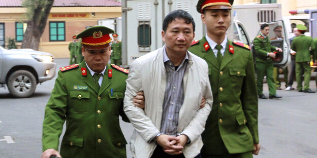 Trinh Xuan Thanh wird von Uniformierten verbracht.