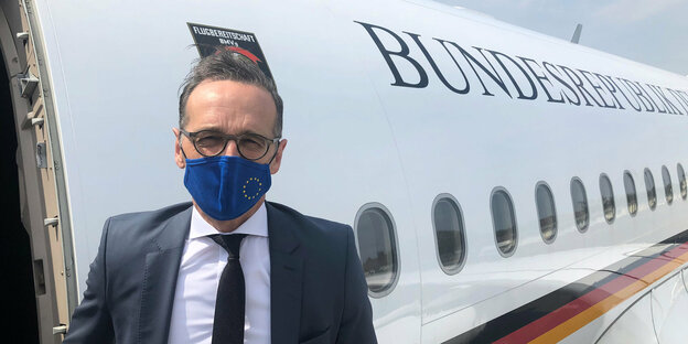 Außenminister Heiko Maas vor einem Flugzeug.