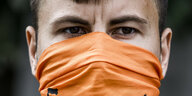 Ein Mann mit einem Schal als Mund-Nase-Schutz