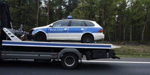 Ein Streifenwagen der Polizei auf einem Abschleppfahrzeug.