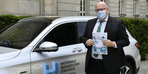 Airtschaftsminister Altmaier steht mit Mundschutz vor einem Auto mit dem aUFKLEBER