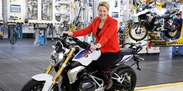 Bundesfamilienministerin Franziska Giffey steigt in einem Montagewerk auf ein Motorrad.