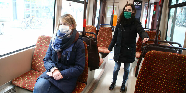 Fahrgäste mit Mundschutz in einem Linienbus