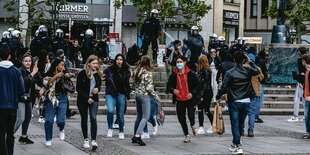 Polizist bestrüht Passanten und demonstranten mit Flüssigkeit.