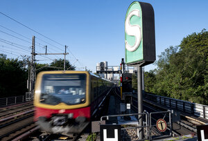 S-Bahn fährt an einem S-Bahnsymbol vorbei